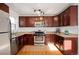 Updated kitchen with dark wood cabinets, granite counters, and stainless steel appliances at 1283 Trenton St, Denver, CO 80220