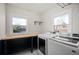 Bright laundry room, featuring washer, dryer, and built-in shelving at 1283 Trenton St, Denver, CO 80220