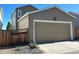 Attached garage with a sectional door and light brown exterior at 183 Mt Bierstadt St, Brighton, CO 80601