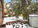 Snowy backyard with deck, storage shed, and mature trees at 4009 Wonderland Hill Ave, Boulder, CO 80304