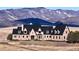 Brick estate home with a grand entrance and mountain backdrop at 7755 Moore Rd, Littleton, CO 80125