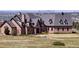 Luxury home with stone exterior, circular drive, and city views at 7755 Moore Rd, Littleton, CO 80125