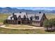 Luxury home with stone exterior, circular drive, and mountain views at 7755 Moore Rd, Littleton, CO 80125