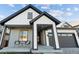 Front view of charming farmhouse style home with gray and white exterior, and a covered porch at 17577 Drake St, Broomfield, CO 80023