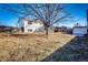 Large backyard with a dog kennel and mature tree at 241 Birch St, Bennett, CO 80102