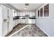 White kitchen with laminate flooring and a pass-through window at 241 Birch St, Bennett, CO 80102