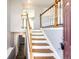 Wooden staircase with white railings in the entryway at 241 Birch St, Bennett, CO 80102