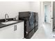 Laundry room with dark gray washer and dryer, and a single sink at 5300 Soledad Cir, Parker, CO 80134
