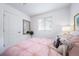 Bright bedroom with pink bedding, window, and built-in shelving at 13448 E 103Rd Pl, Commerce City, CO 80022