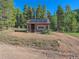 Rustic log cabin with solar panels, nestled in a wooded area at 9719 Beaver Pond, Conifer, CO 80433