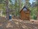 Log shed and outdoor kitchen with grill in wooded area at 9719 Beaver Pond, Conifer, CO 80433