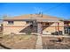 Back of house with covered patio and firepit at 7887 Quivas Way, Denver, CO 80221