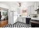 Kitchen with white cabinets, black and white checkered floors, and stainless steel appliances at 7887 Quivas Way, Denver, CO 80221