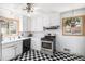 Bright kitchen featuring white cabinets, stainless steel appliances, and a checkerboard floor at 7887 Quivas Way, Denver, CO 80221