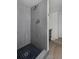 Walk-in shower with gray tile and a modern showerhead at 1924 S Huron St, Denver, CO 80223