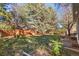 Large backyard with mature trees and a wooden fence at 9641 Sierra Dr, Arvada, CO 80005
