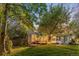 Spacious backyard with a deck and mature trees, at dusk at 9641 Sierra Dr, Arvada, CO 80005