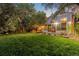 House backyard view with a large green lawn and screened porch at 9641 Sierra Dr, Arvada, CO 80005