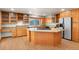 Kitchen with island, wood cabinets, granite countertops at 9641 Sierra Dr, Arvada, CO 80005