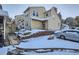 Tan two-story townhome with snow covered landscaping and parking at 3923 E 121St Ave, Thornton, CO 80241