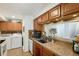 Functional kitchen with laundry hookups, wood cabinets, and a pass-through to dining area at 13 Nome Way # A, Aurora, CO 80012