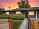 Brick home with a gray door and landscaped yard at 6325 Martin Luther King Jr Blvd, Denver, CO 80207