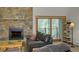 Cozy living room features a stone fireplace, leather sofa, and access to a balcony at 465 Four Oclock Rd # 323, Breckenridge, CO 80424
