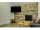 Living room with stone fireplace, large TV, and comfortable seating at 465 Four Oclock Rd # 323, Breckenridge, CO 80424