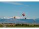 Aerial view of community with hot air balloons and mountain backdrop at 1040 Sunrise Dr, Erie, CO 80516