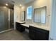 Double vanity bathroom with a large mirror, shower, and dark brown cabinetry at 1040 Sunrise Dr, Erie, CO 80516