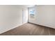 Well-lit bedroom with neutral walls, brown carpet, and a window showcasing a distant view at 7302 Arkansas Street, Frederick, CO 80530