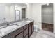 Bathroom with double vanity, shower, and walk-in closet at 7302 Arkansas Street, Frederick, CO 80530