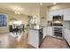 Bright open kitchen with white cabinets, stainless steel appliances, and an island at 14674 E Crestridge Dr, Centennial, CO 80015