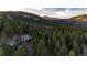 Aerial view of house and surrounding mountain landscape at 32651 Buffalo Creek Rd, Evergreen, CO 80439