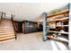 Finished basement with stylish shelving, stairs and a modern feel at 32651 Buffalo Creek Rd, Evergreen, CO 80439