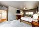 Spacious main bedroom with large TV, wood furniture, and carpet flooring at 32651 Buffalo Creek Rd, Evergreen, CO 80439