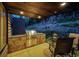 Built-in outdoor kitchen with grill and seating area at 32651 Buffalo Creek Rd, Evergreen, CO 80439