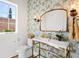 Powder room with gold vanity, floral wallpaper, and a large mirror at 428 S Williams St, Denver, CO 80209