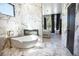 Luxurious bathroom with soaking tub, marble finishes, and a walk-in shower at 4960 S Lipan Dr, Englewood, CO 80110