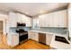 Renovated kitchen featuring white cabinets, stainless steel appliances, and hardwood floors at 212 S Sherman St, Denver, CO 80209