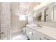 Modern bathroom with white subway tile, white vanity, and hexagon tile floor at 212 S Sherman St, Denver, CO 80209