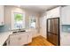Updated kitchen boasts white cabinets, stainless steel appliances, and hardwood floors at 212 S Sherman St, Denver, CO 80209