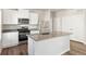 Modern kitchen with white cabinets, stainless steel appliances, and an island at 3030 Oxley St, Strasburg, CO 80136