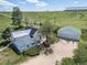 Aerial view of a farmhouse, detached garage, and expansive land at 8045 N Moore Rd, Littleton, CO 80125