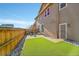 Landscaped backyard with artificial turf, a patio, and a wooden fence at 9091 E 59Th North Pl, Denver, CO 80238