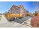 View of the back of house and private backyard with a wooden fence and a paved driveway at 9091 E 59Th North Pl, Denver, CO 80238