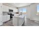 Modern kitchen with island, stainless steel appliances, and access to deck at 3282 N Highlands Creek Pkwy, Aurora, CO 80019