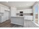 Modern kitchen with island, stainless steel appliances, and access to deck at 3282 N Highlands Creek Pkwy, Aurora, CO 80019