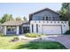 Two-story home with gray and white exterior, landscaped yard, and attached garage at 3790 S Roslyn Way, Denver, CO 80237