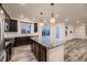 Open concept kitchen with island, dark cabinets and stainless steel appliances at 9307 Inca Dove Cir, Littleton, CO 80125